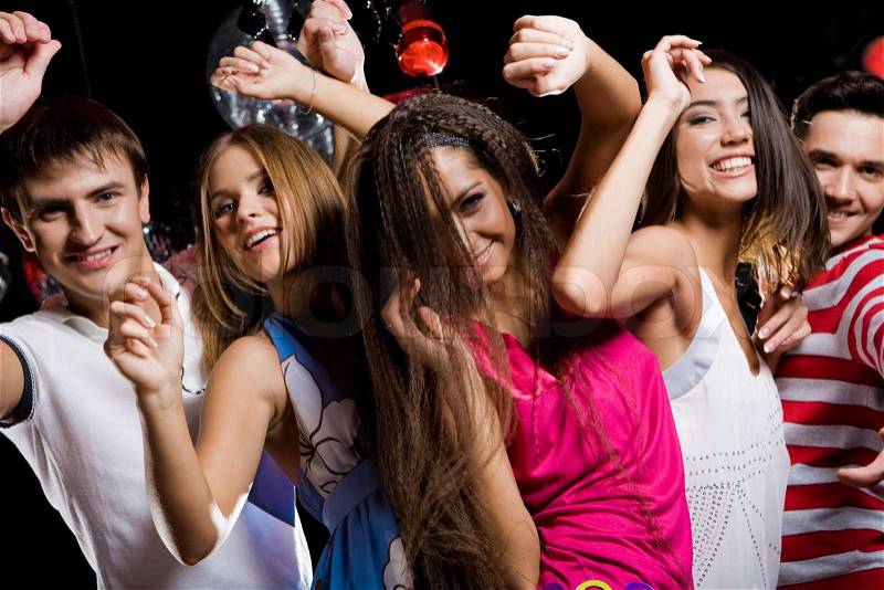 Company of cheerful teens enjoying themselves while dancing at disco, stock photo