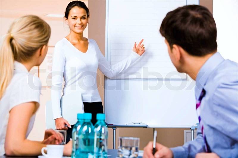 Portrait of business woman demonstrating something on the whiteboard at seminar, stock photo