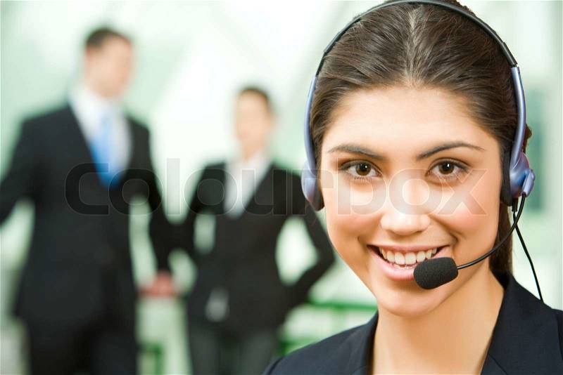 Portrait of friendly consultant with headset on the background of people , stock photo