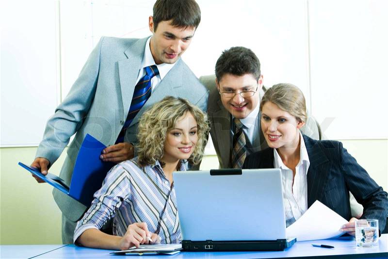 Photo of confident people looking at laptop screen at meeting in the office, stock photo