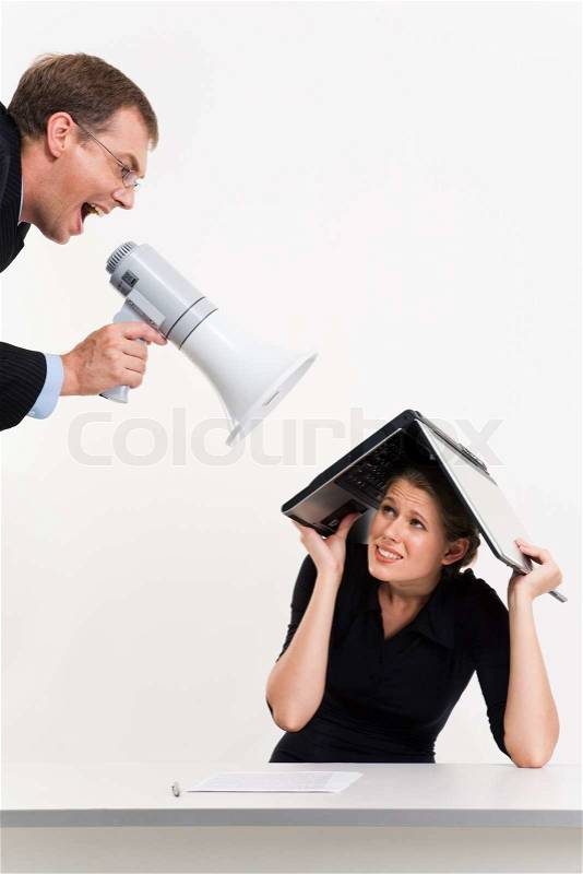 Portrait of confident boss shouting at woman under laptop, stock photo