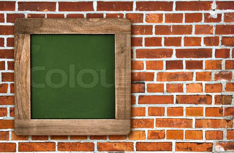 Square chalkboard with wooden frame over red brick wall background, stock photo
