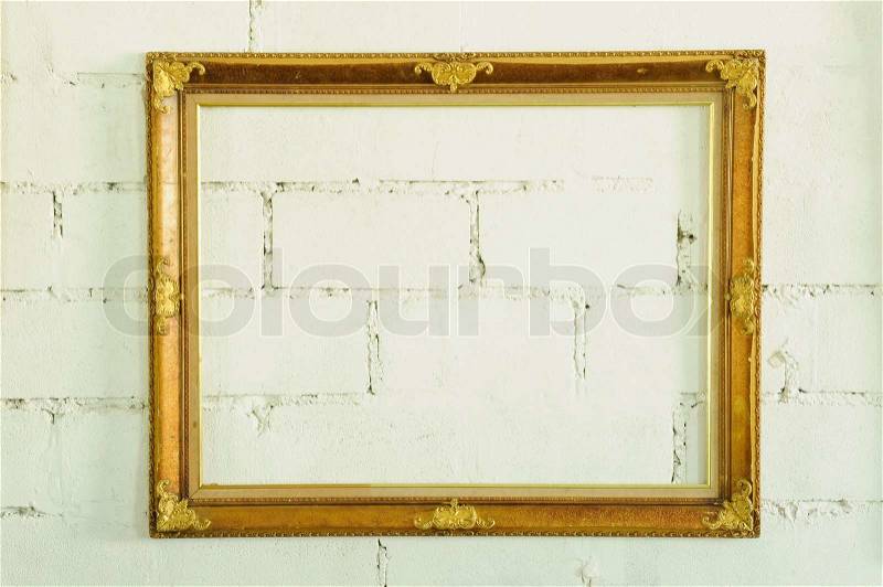 Vintage gold picture frame on white wall, stock photo