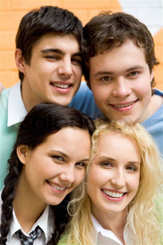 Company of friendly teenagers looking at camera and smiling, stock photo