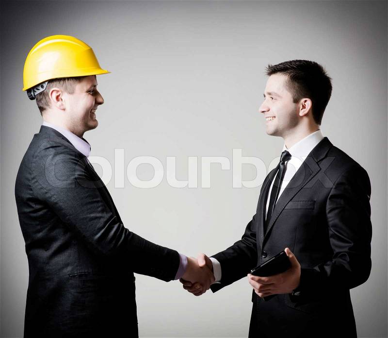 Handsome business man handshake with construction, stock photo