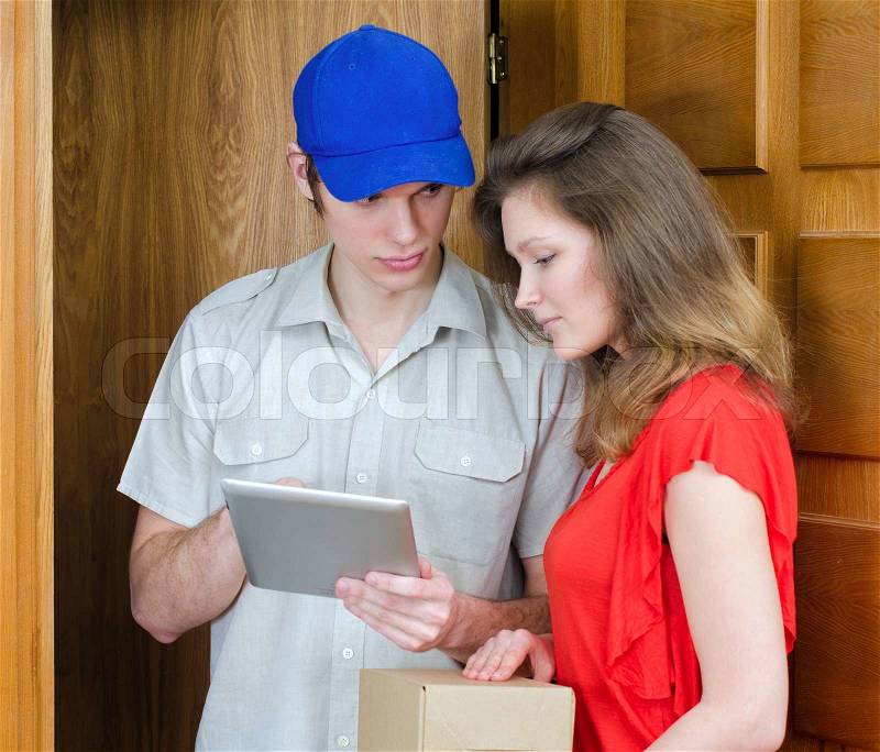 Young courier deliver package to pretty woman, stock photo