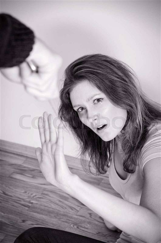 Man with knife coming to his wife. Home violence concept. Black and white, stock photo