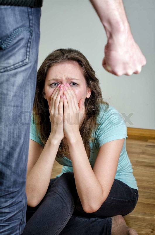Home violence concept. Frightened woman and men\'s fist, stock photo