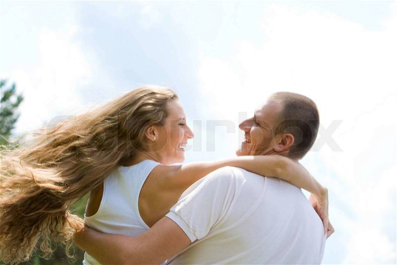 Happy male and female looking at each other and both laughing, stock photo
