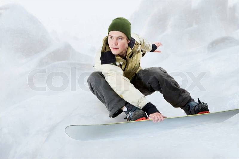Portrait of young man going in for snowboarding in winter, stock photo