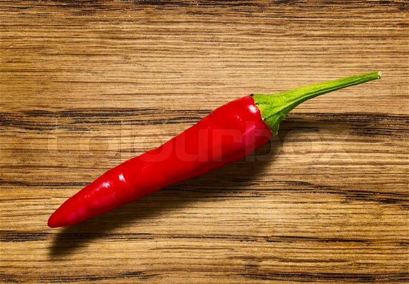Red chili pepper on wooden table, stock photo