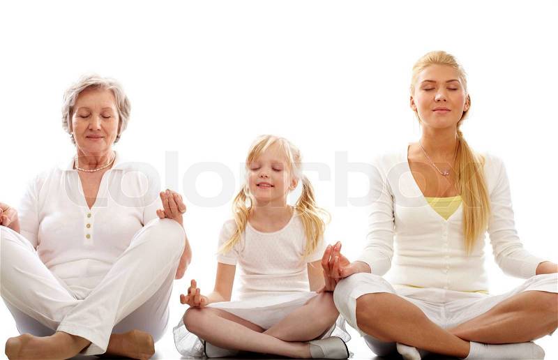 Row of grandmother, mother and child meditating together, stock photo