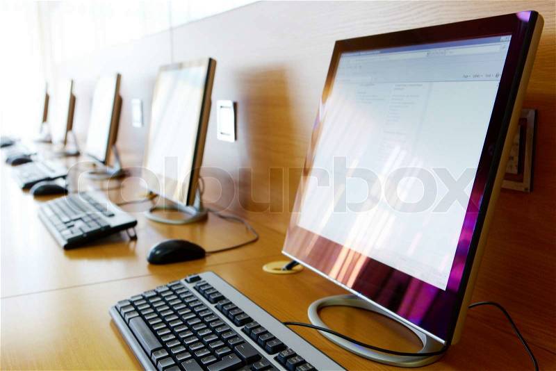 Photo of row of computers in classroom of college or other educational institution, stock photo