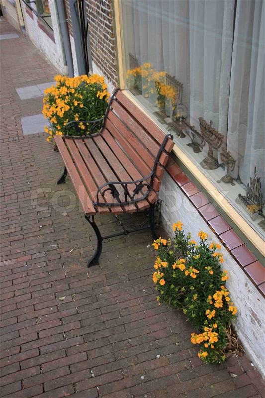 An empty bench before the window in the residential area in the village, stock photo