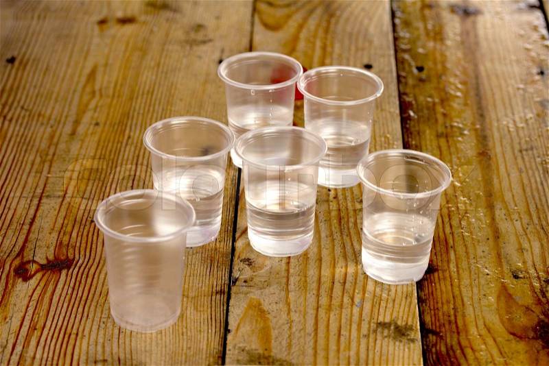 Plastic cups of water on the wooden background, stock photo