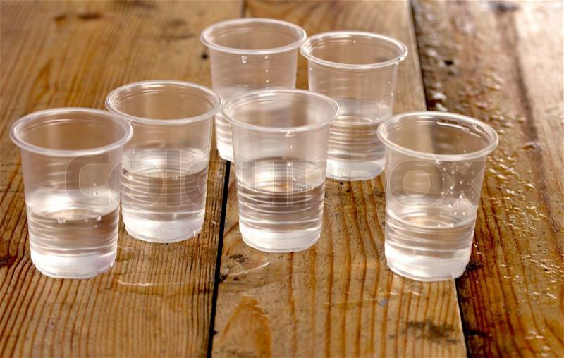 Plastic cups of water on the wooden background, stock photo