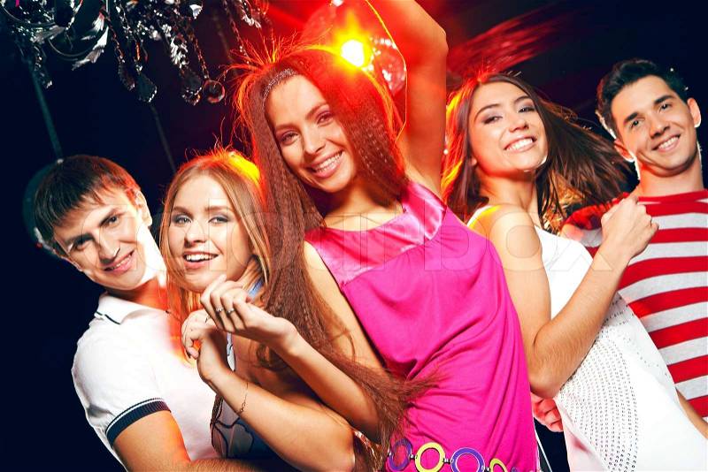 Company of cheerful teens enjoying themselves while dancing at disco, stock photo