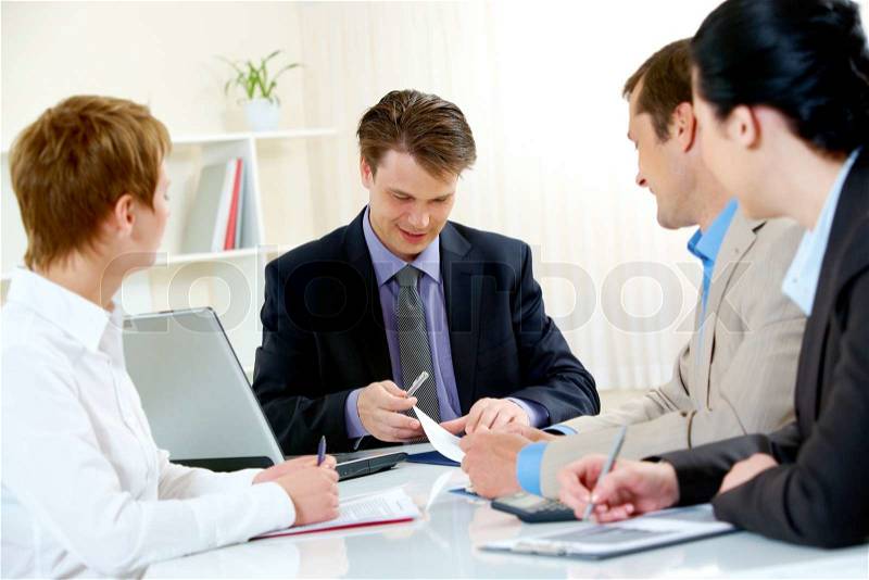 Portrait of confident manager looking at document and giving consulting to business people , stock photo