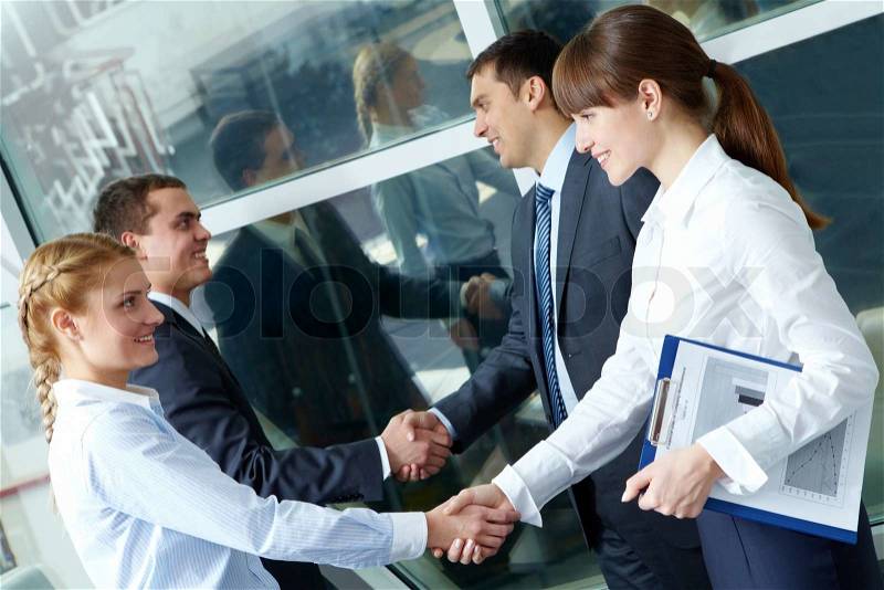 Photo of two pairs of confident partners handshaking after making an agreement, stock photo
