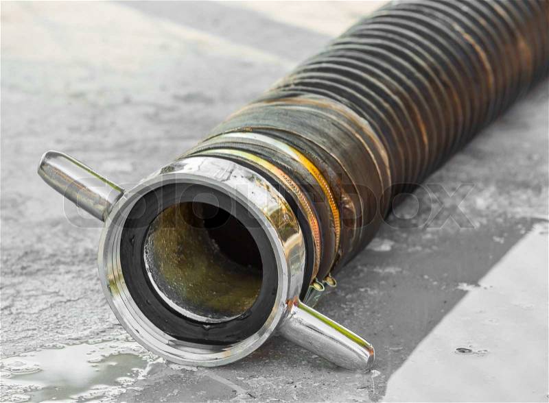 Close up pump suction hose on wet concrete floor, stock photo