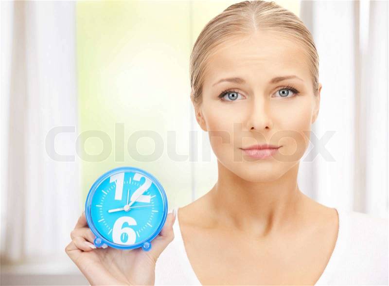 Bright picture of woman holding alarm clock, stock photo