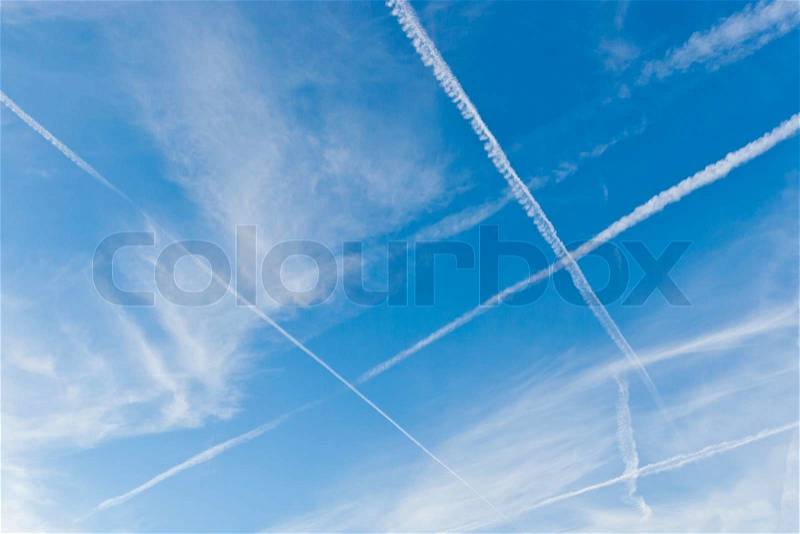 Blue sky with crossing vapor trails, stock photo