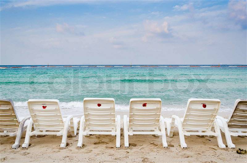 White deck chairs on the beach, sunrise time, stock photo