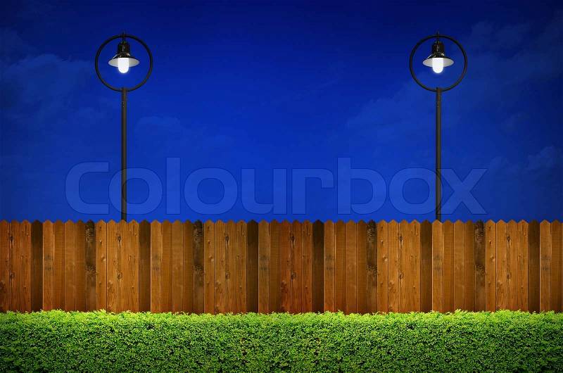 Street lighting with shrub and wooden fence, stock photo