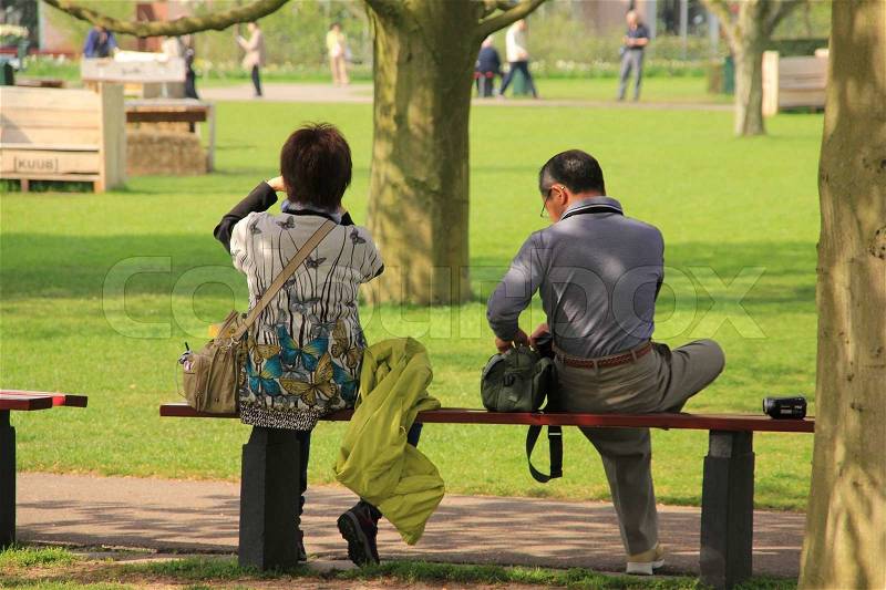 Happy retired couple have a break and have a nice view in park in spring, stock photo