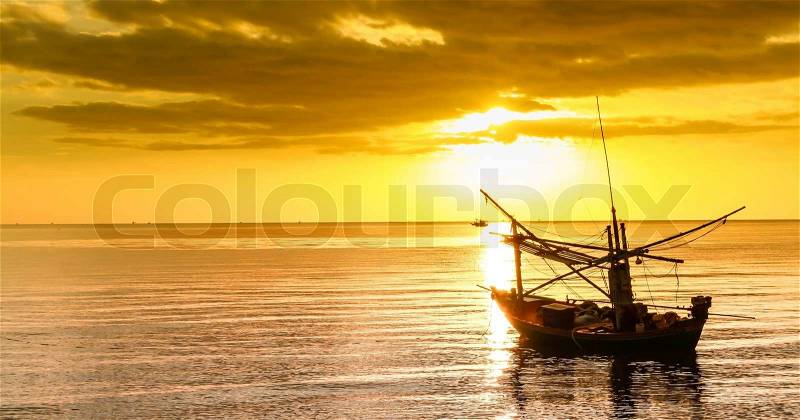 Fishing boat at sunset, stock photo