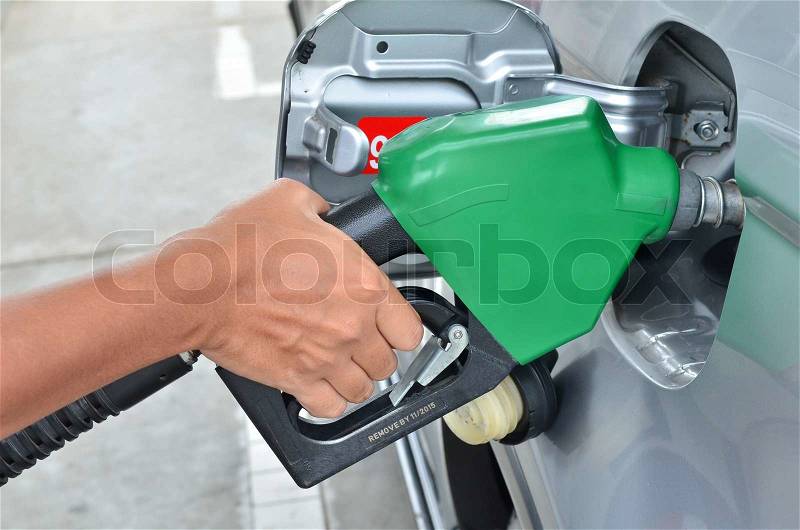 A man pumping gas in to the tank, stock photo