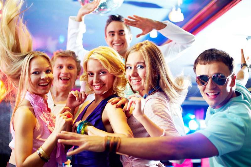 Portrait of glamorous girls dancing at party with happy friends near by, stock photo