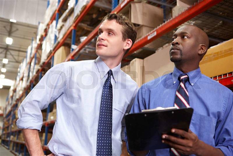 Two Businessmen With Clipboard In Warehouse, stock photo
