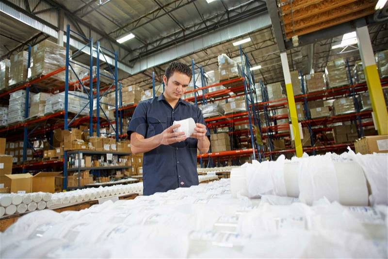 Factory Worker Checking Goods On Production Line, stock photo