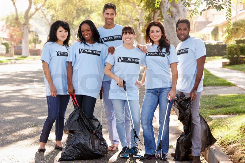 Team Of Volunteers Picking Up Litter In Suburban Street, stock photo