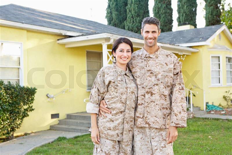 Military Couple In Uniform Standing Outside House, stock photo