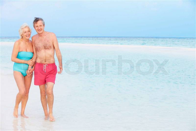 Senior Romantic Couple Walking In Beautiful Tropical Sea, stock photo