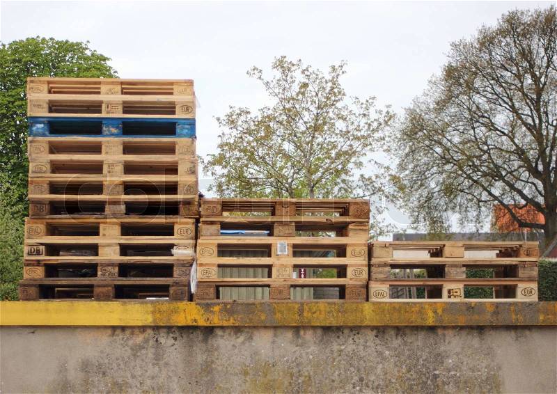 Three piles of wodden Europe pallets with one in color, stock photo