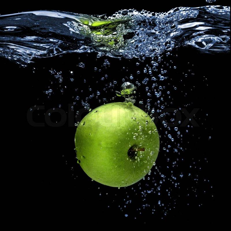 Green apple dropped into water with splash isolated on black, stock photo