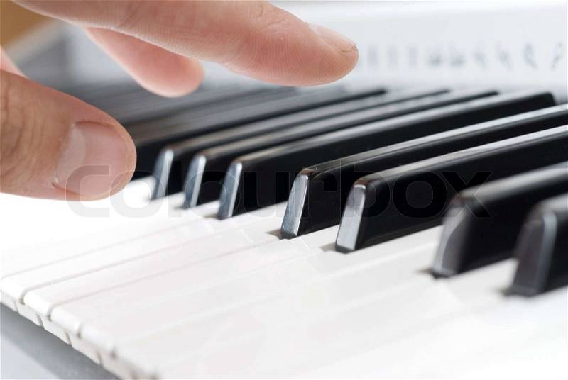 Hand playing music on the piano, stock photo