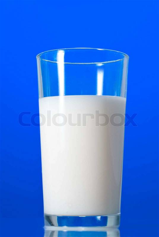 Milk in glass isolated on blue, stock photo