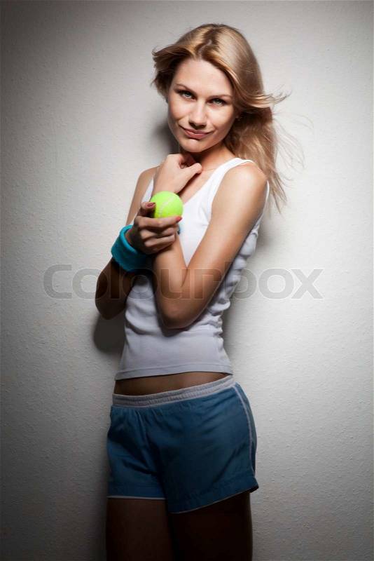 Portrait of young smiling woman with tennis racket and ball on white, stock photo