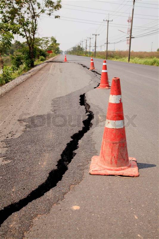 Traffic cones on the cracked asphalt road, stock photo