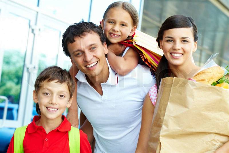 Couple with paperbags and their two children after shopping, stock photo
