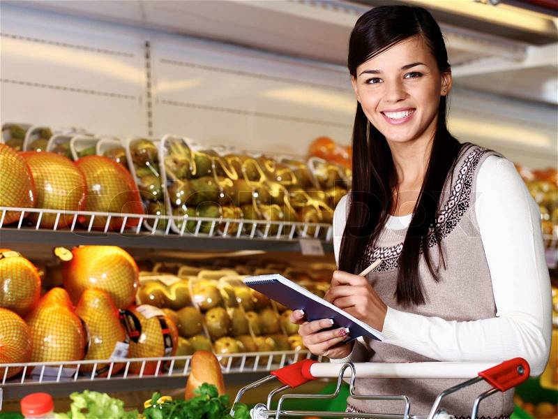 Image of pretty woman looking at camera while choosing products in supermarket, stock photo