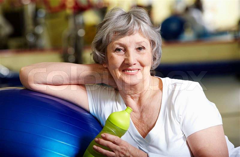 Portrait of senior woman in sportswear looking at camera and smiling , stock photo