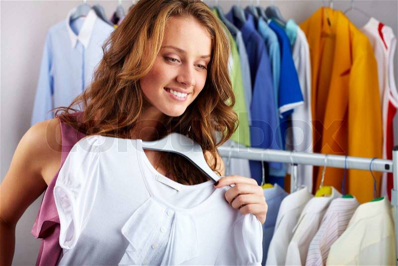 A girl choosing a t-shirt in the shop, stock photo