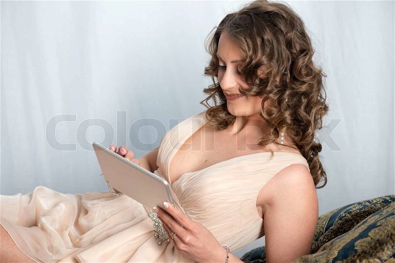 Beautiful young woman relaxing in her old house with new Tablet, stock photo