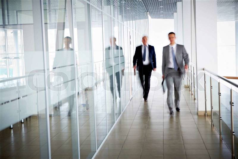 Business people walking in the office corridor, stock photo