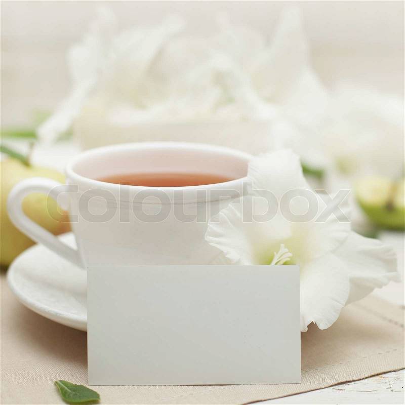 White blank paper, gladiolus flower and tea cup, stock photo